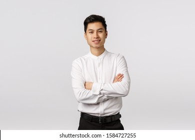 Cheerful, Lucky And Successful Good-looking Asian Young Male Entrepreneur, Finished Business School And Ready Handle Any Task Work, Cross Arms Over Chest, Smiling Pleased, White Background