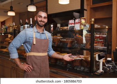 Cheerful male baker welcoming you at his bakery store, copy space - Powered by Shutterstock