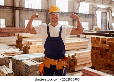 Cheerful Male Builder Demonstrating His Muscular Arms