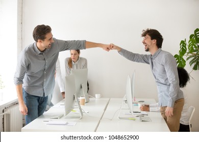 Cheerful male colleagues fist bumping celebrating successful teamwork in office, friendly happy motivated coworkers excited by good work result congratulating each other with professional achievement - Powered by Shutterstock
