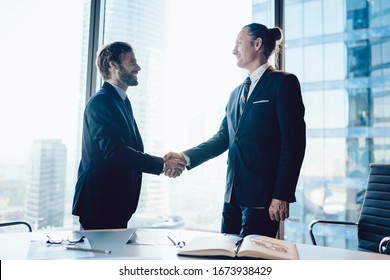 Cheerful Male Colleagues In Formal Elegant Suit Satisfied With Getting Agreement On Business Cooperation After Meeting In Office,men Managers Gesturing Shaking Hands Having Friendly Conversation