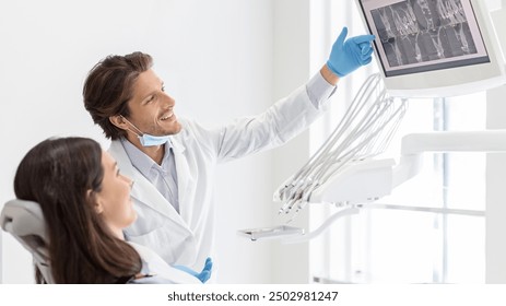 Cheerful male dentist doctor showing his patient x-ray results on lcd display, side view, copy space - Powered by Shutterstock