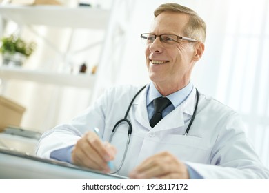 Cheerful Male Doctor In Lab Coat Working In Clinic