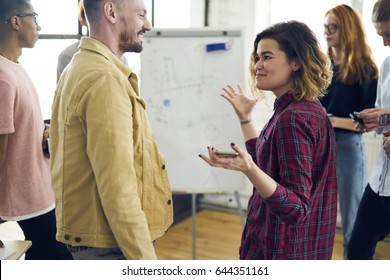 Cheerful male and female colleagues having fun joking while resting after working session on break in coworking space, hipster girl communicating with friends telling interesting stories in good mood - Shutterstock ID 644351161