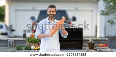 cheerful man barbecuing trout fillet at backyard. photo of man barbecuing trout fillet on grill.