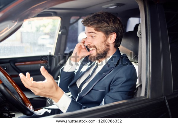 Cheerful man in the car talking on the phone            \
                  