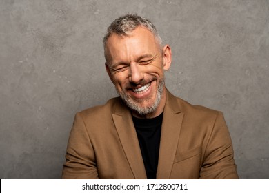 Cheerful Man With Closed Eyes Laughing On Grey