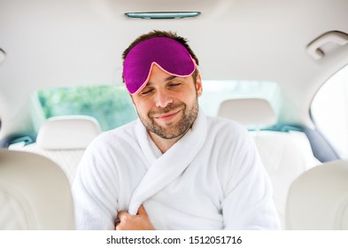 Cheerful Man With Dressing Gown And Eye Mas Sitting In Car, Eyes Closed.