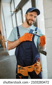 Cheerful Man Fixing Window With Silicone Adhesive Gun