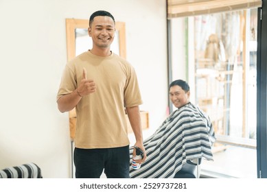 A cheerful man with a friendly demeanor is giving a thumbs up gesture while enjoying a haircut at his local barber shop - Powered by Shutterstock