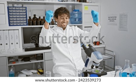 A cheerful man in a lab coat celebrates a breakthrough in a laboratory with test tubes and scientific equipment.