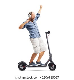 Cheerful man listening to music and dancing while riding an electric scooter, isolated on white background