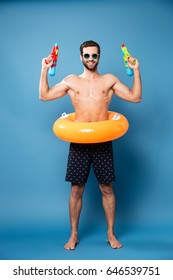 Cheerful man looking camera while holding water guns isolated