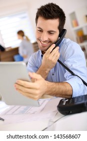 Cheerful Man In Office Answering The Phone