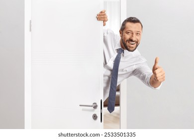 Cheerful man opening a door and gesturing thumbs up - Powered by Shutterstock