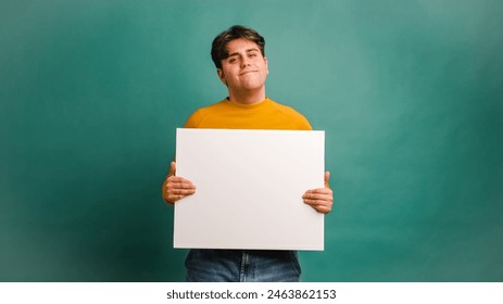 Cheerful man showing blank banner in studio - Powered by Shutterstock