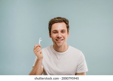 Cheerful Man Showing A Dental Floss Pick