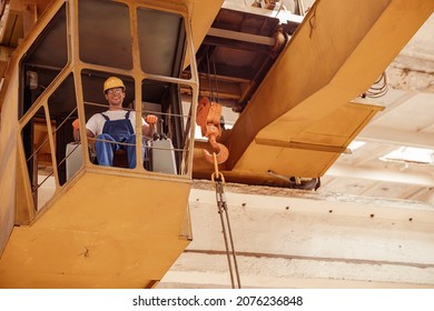 Cheerful Man Sitting In Operator Cabin Of Overhead Crane
