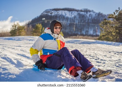 Cheerful Man Sledding Down A Snowy Slope In Full Speed