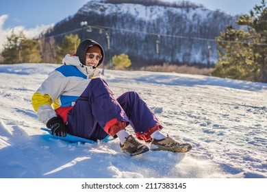 Cheerful Man Sledding Down A Snowy Slope In Full Speed