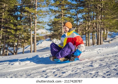 Cheerful Man Sledding Down A Snowy Slope In Full Speed