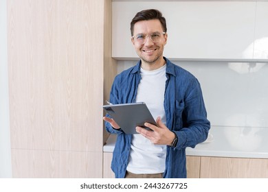 A cheerful man with a tablet offers a warm, engaged presence in a bright kitchen setting.

 - Powered by Shutterstock