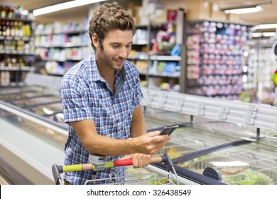 Cheerful Man Using App Mobile Phone In Store