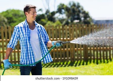 Cheerful Man Watering Home Garden