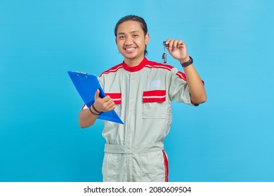 Cheerful man wearing mechanic uniform holding clipboard and showing vehicle keys isolated on blue background - Powered by Shutterstock