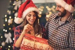 Cheerful Man And Woman Opens Christmas Gift 
