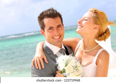 Cheerful married couple standing on the beach