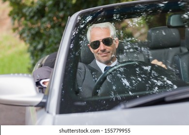 Cheerful mature businessman driving classy cabriolet on sunny day - Powered by Shutterstock