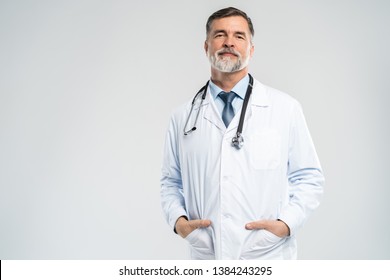 Fröhliche, reife Ärzte, die sich unter Kamera, Gesundheitswesen und Medizin posieren und lächeln