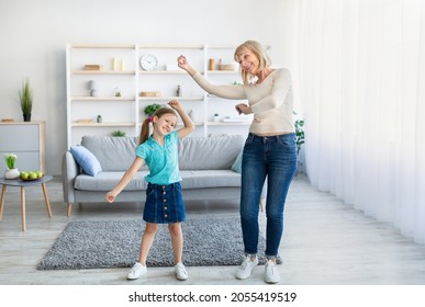 Cheerful Mature Grandparent And Preschool Adorable Daughter Moving Dancing To Music In Living Room, Little Girl And Older Lady Having Fun Enjoying Free Time At Home. Funny Leisure Activities Concept