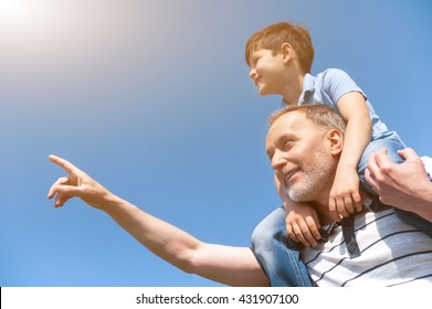 Cheerful Mature Grandparent Is Teaching His Grandchild