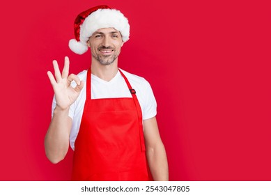 cheerful mature man in red barista apron and christmas santa hat - Powered by Shutterstock