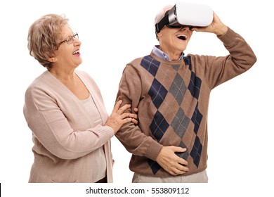 Cheerful mature man using a VR headset with a mature woman holding his hand isolated on white background - Powered by Shutterstock