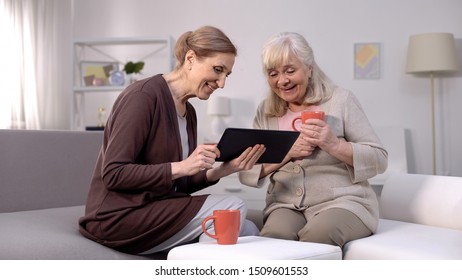 Cheerful mature women watching tablet video, shopping application, technology