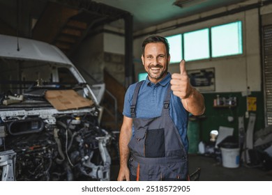 A cheerful mechanic in overalls smiles confidently, giving a thumbs up in a workshop, conveying satisfaction and readiness to assist with any car repairs. - Powered by Shutterstock