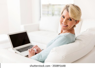 Cheerful Mid Age Woman With Laptop Computer At Home