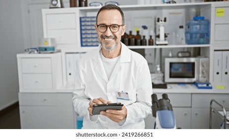 Cheerful middle age man, a scientist with grey hair, joyfully using a touchpad while conducting his research in the vibrant atmosphere of his lab. - Powered by Shutterstock