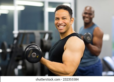 Cheerful Middle Aged Man Lifting Weights In Gym