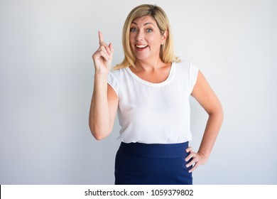 Cheerful Middle Aged Woman Finding New Idea And Raising Index Finger. Mature Woman Pointing Up At Copy Space. Advertising Or New Idea Concept