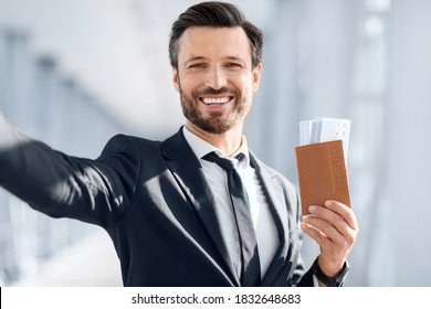 Cheerful Middle-aged Businessman Taking Selfie Before Departure, Showing Passport With Flight Tickets, Waiting For Departure In Airport, Copy Space. Man In Suit Taking Photo, Sharing With Family