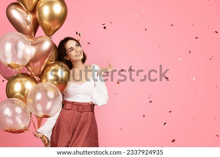 Cheerful millennial caucasian brunette lady with many balloons enjoy confetti, isolated on pink background, studio. Ad and offer, lifestyle, holiday celebration, birthday party and fun