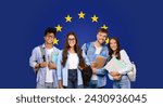 Cheerful millennial group of four college friends with books standing before a European Union flag, representing international study opportunities or Erasmus program, panorama