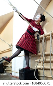 Cheerful Mime Girl In Red Dress Pulls Rope