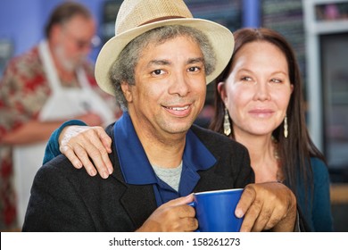 Cheerful mixed couple together in coffee house