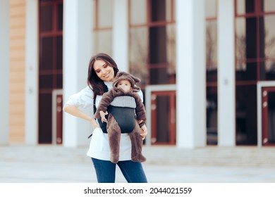 Cheerful Mom Walking Her Cute Infant In Baby Carrier. Mother Running Errands With Carrying Her Newborn Child With Her
