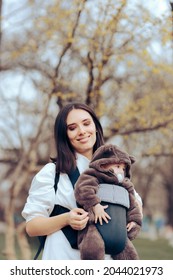 Cheerful Mom Walking Her Cute Infant In Baby Carrier. Mother Running Errands With Carrying Her Newborn Child With Her
